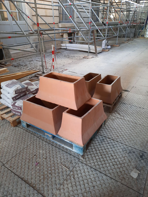 Mitres en terre cuite préparées pour la livraison sur le chantier.